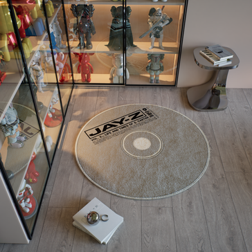 A stylish room featuring a round rug designed like a Jay-Z album cover with "Vol. 3... Life and Times of S. Carter" text. CD Rug.